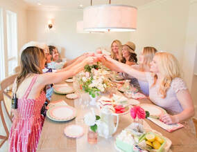 Host serving tea in vintage china cups at a Dolly Parton themed tea party in Nashville, ideal for bachelorette parties